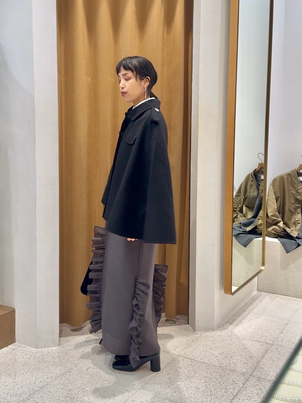 ブラック系のブーツ、ブラック系のショルダーバッグ、グレー系のワンピースを着用したレディースの秋コーディネートの5枚目の写真