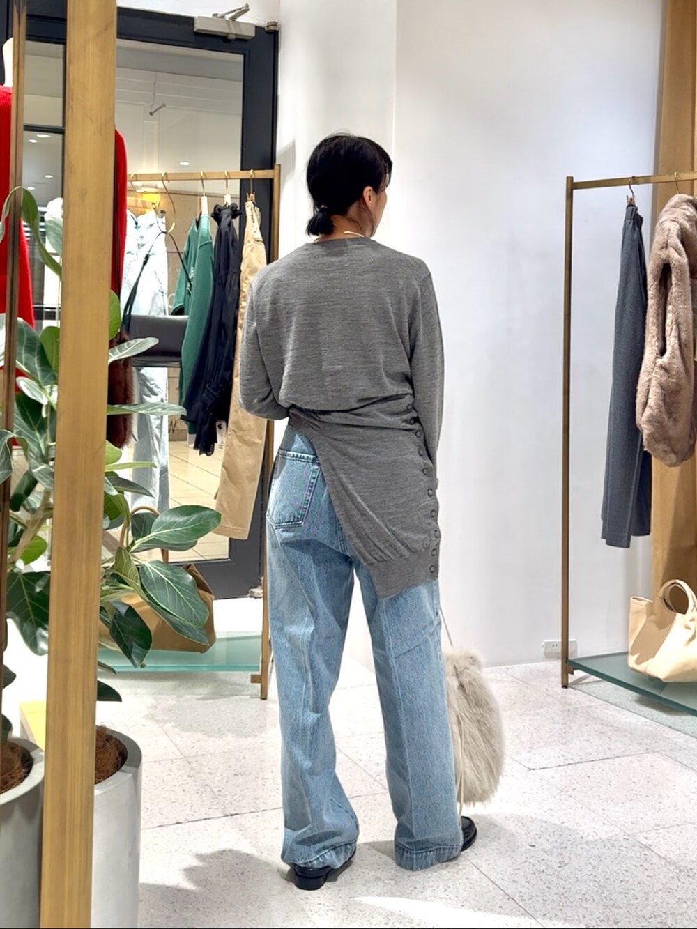 グレー系のカーディガン/ボレロ、グレー系のニット/セーター、ブルー系のデニムパンツを着用したレディースの秋コーディネートの7枚目の写真