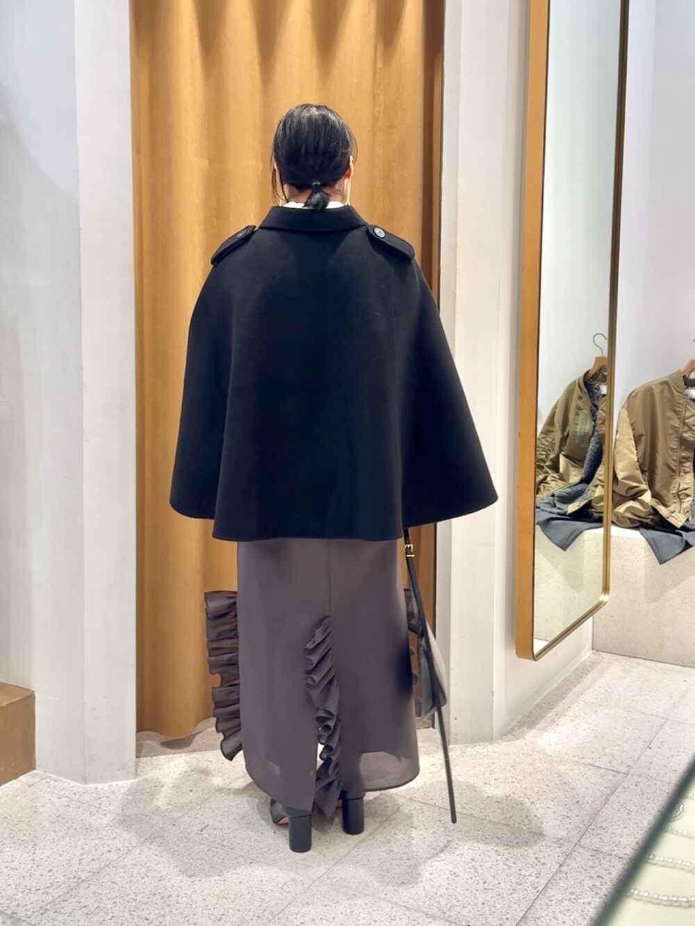 ブラック系のブーツ、ブラック系のショルダーバッグ、グレー系のワンピースを着用したレディースの秋コーディネートの4枚目の写真