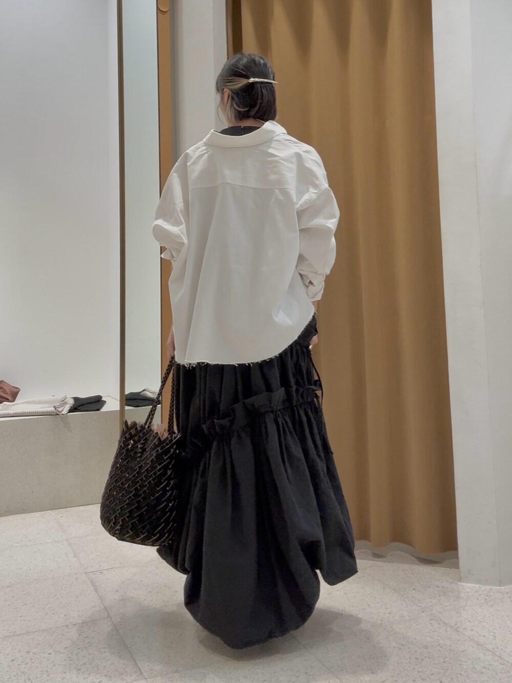 ホワイト系のシャツ/ブラウス、シルバー系のバレッタ/ヘアクリップ、ブラック系のブレスレットを着用したレディースの春コーディネートの3枚目の写真