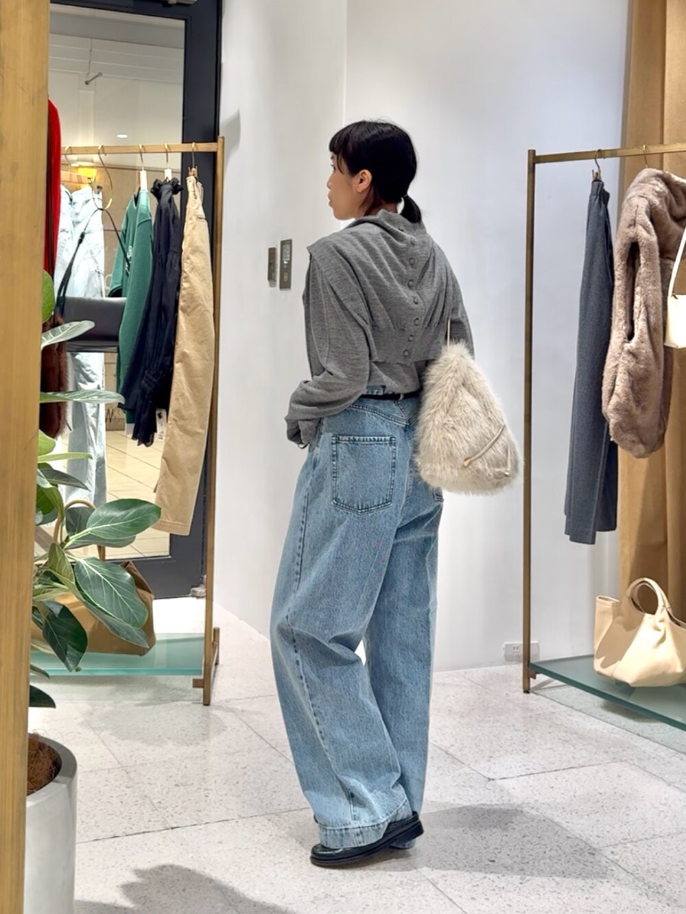 グレー系のカーディガン/ボレロ、グレー系のニット/セーター、ブルー系のデニムパンツを着用したレディースの秋コーディネートの2枚目の写真