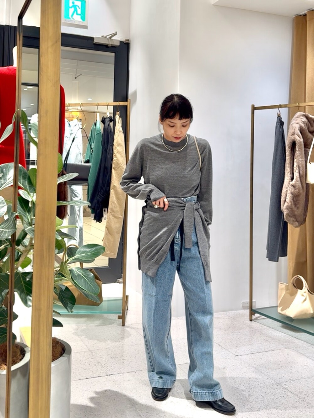 グレー系のカーディガン/ボレロ、グレー系のニット/セーター、ブルー系のデニムパンツを着用したレディースの秋コーディネートの9枚目の写真