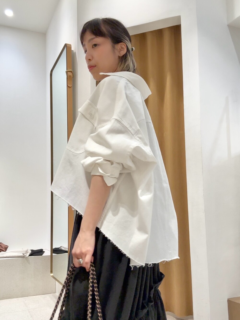 ホワイト系のシャツ/ブラウス、シルバー系のバレッタ/ヘアクリップ、ブラック系のブレスレットを着用したレディースの春コーディネートの6枚目の写真