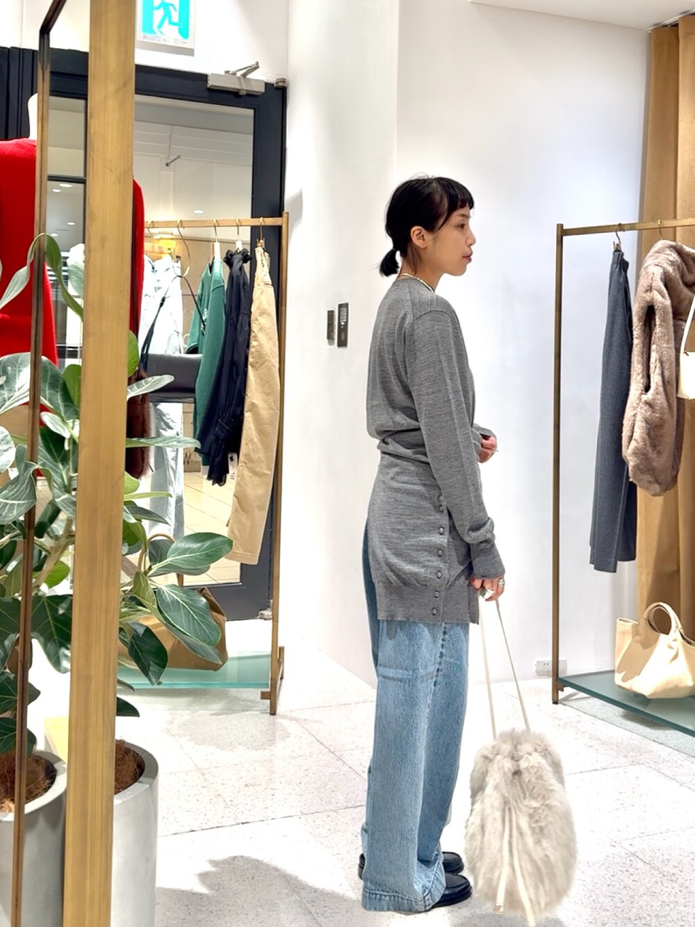 グレー系のカーディガン/ボレロ、グレー系のニット/セーター、ブルー系のデニムパンツを着用したレディースの秋コーディネートの8枚目の写真