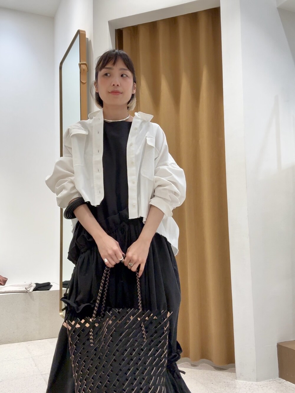 ホワイト系のシャツ/ブラウス、シルバー系のバレッタ/ヘアクリップ、ブラック系のブレスレットを着用したレディースの春コーディネートの5枚目の写真