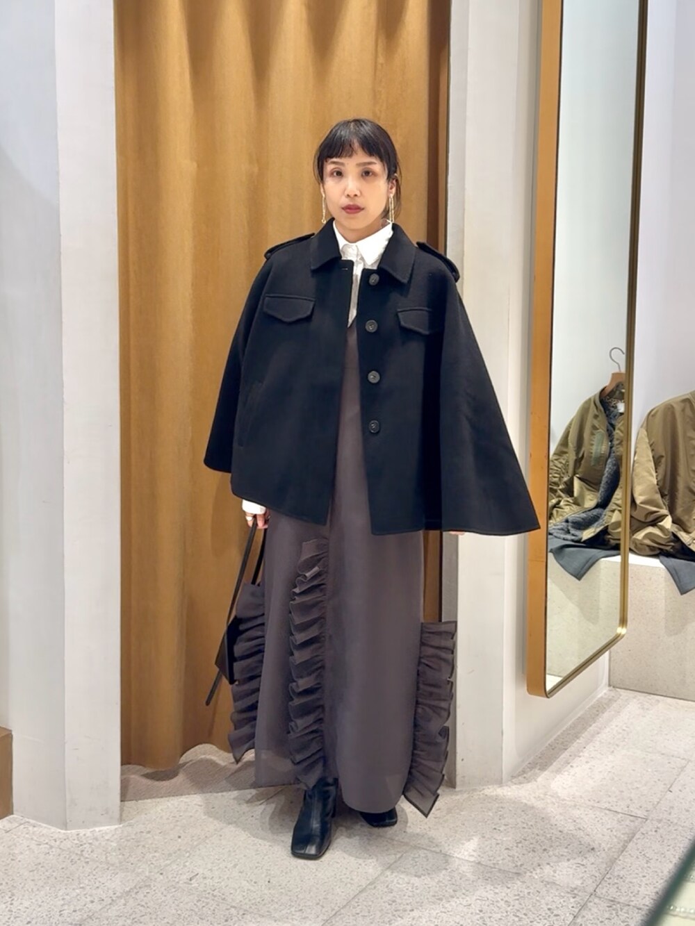 ブラック系のブーツ、ブラック系のショルダーバッグ、グレー系のワンピースを着用したレディースの秋コーディネートの6枚目の写真