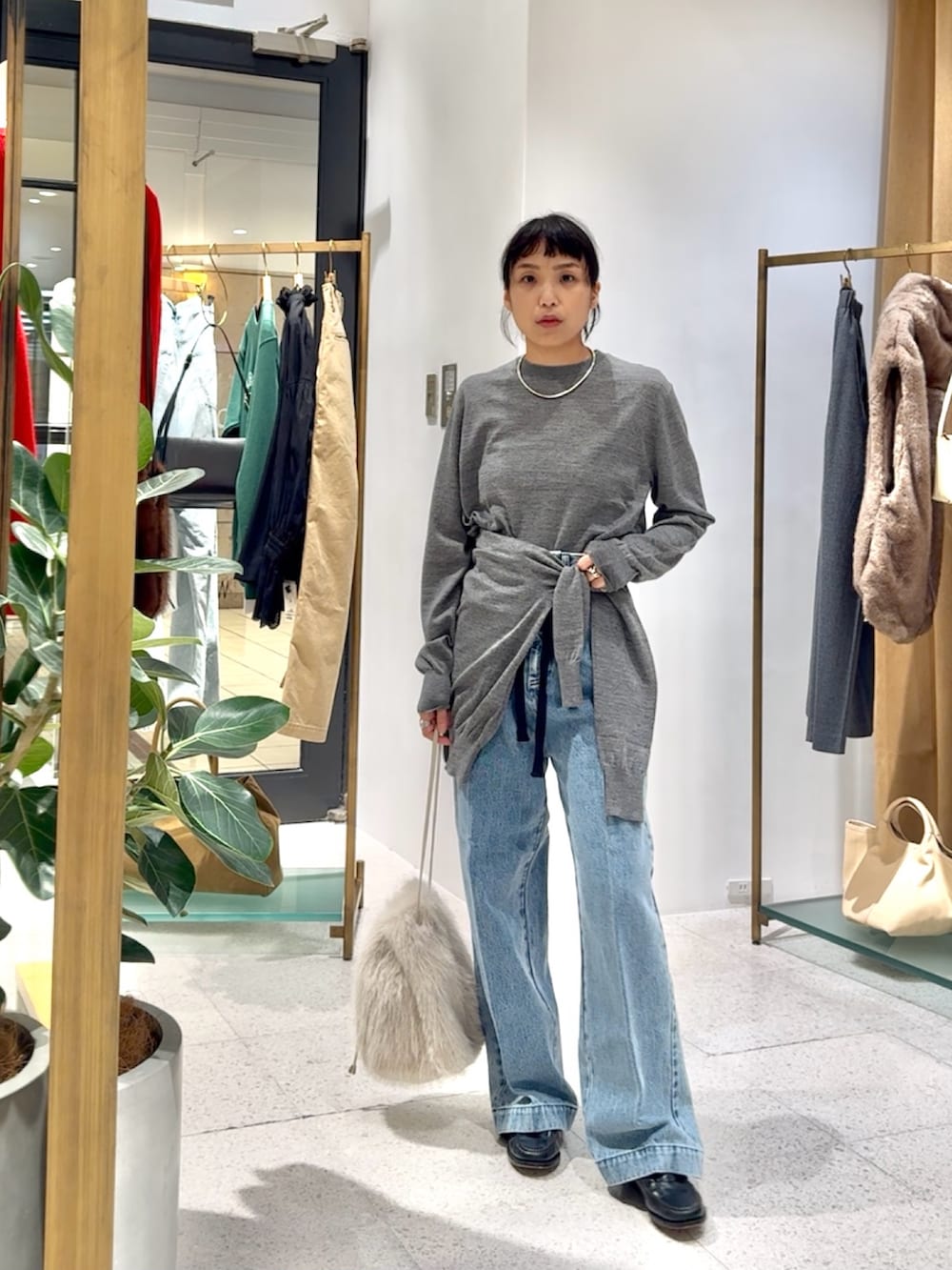 グレー系のカーディガン/ボレロ、グレー系のニット/セーター、ブルー系のデニムパンツを着用したレディースの秋コーディネートの5枚目の写真