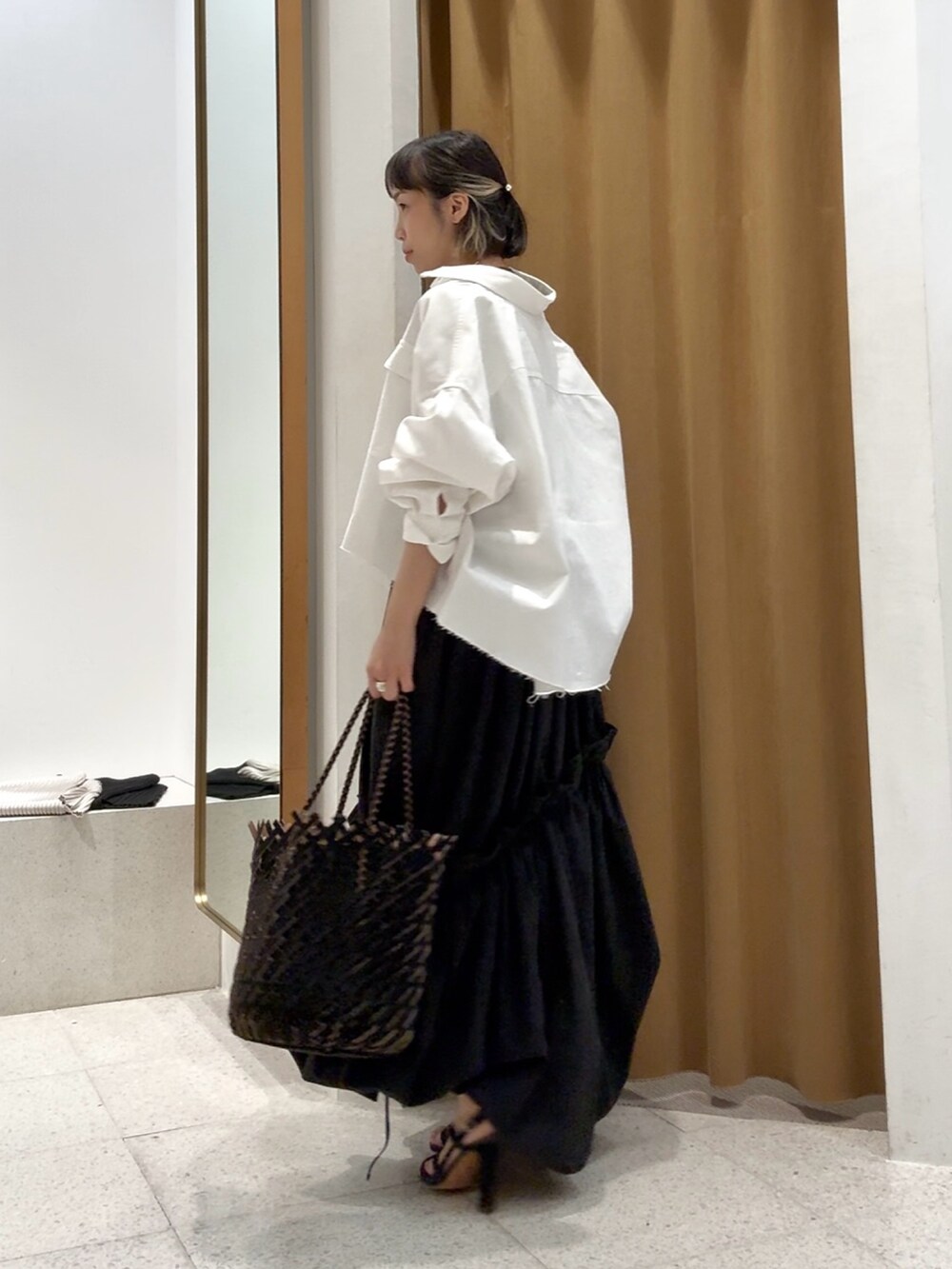 ホワイト系のシャツ/ブラウス、シルバー系のバレッタ/ヘアクリップ、ブラック系のブレスレットを着用したレディースの春コーディネートの2枚目の写真