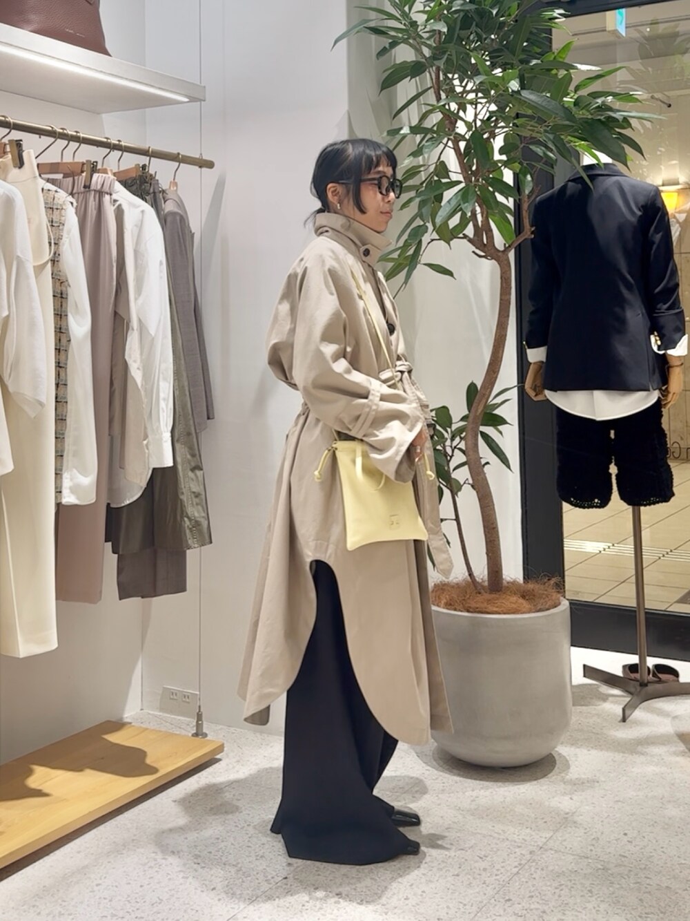 ベージュ系のポンチョ、グレー系のカーディガン/ボレロ、イエロー系のショルダーバッグを着用したレディースの冬コーディネートの5枚目の写真