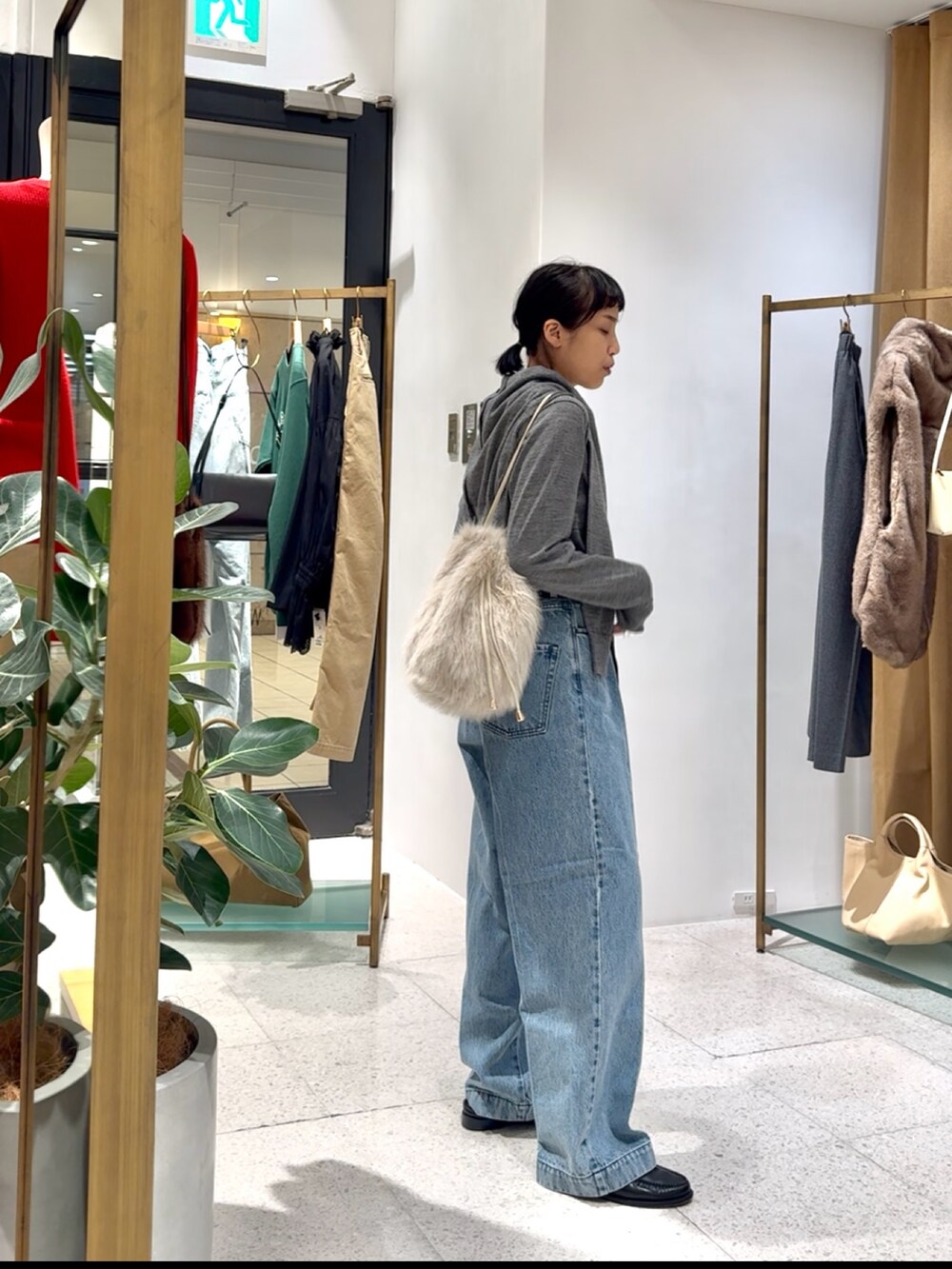 グレー系のカーディガン/ボレロ、グレー系のニット/セーター、ブルー系のデニムパンツを着用したレディースの秋コーディネートの4枚目の写真