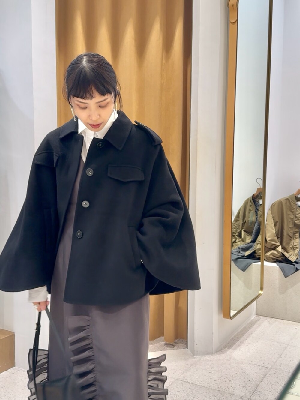 ブラック系のブーツ、ブラック系のショルダーバッグ、グレー系のワンピースを着用したレディースの秋コーディネートの7枚目の写真