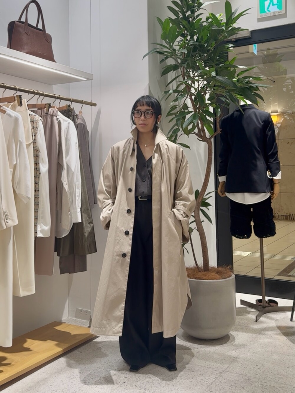 ベージュ系のポンチョ、グレー系のカーディガン/ボレロ、イエロー系のショルダーバッグを着用したレディースの冬コーディネートの2枚目の写真