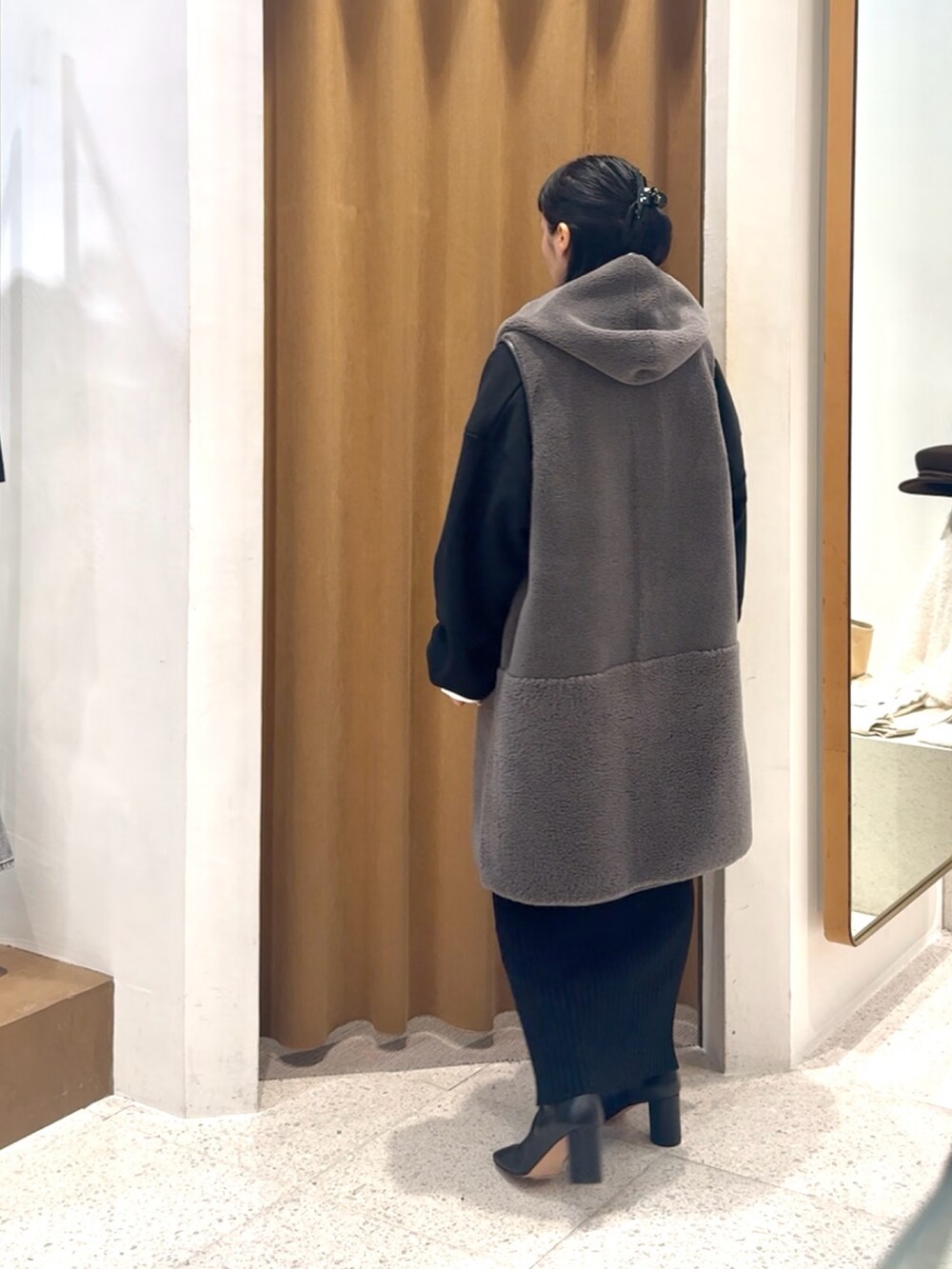 ブラック系のスウェット、グレー系のベスト、ブラック系のボストンバッグを着用したレディースの秋コーディネートの4枚目の写真