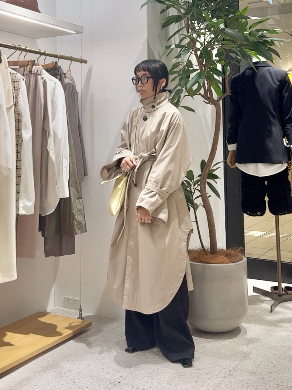 ベージュ系のポンチョ、グレー系のカーディガン/ボレロ、イエロー系のショルダーバッグを着用したレディースの冬コーディネートの8枚目の写真