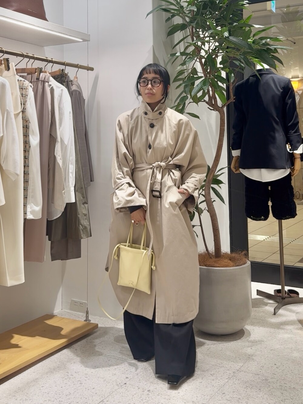 ベージュ系のポンチョ、グレー系のカーディガン/ボレロ、イエロー系のショルダーバッグを着用したレディースの冬コーディネートの6枚目の写真