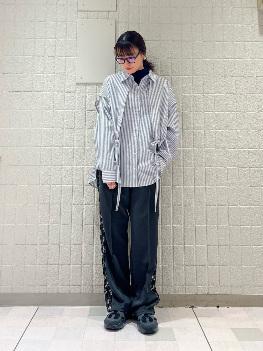 グレー系のステンカラーコート、ホワイト系のシャツ/ブラウス、グレー系のその他パンツを着用したレディースの春コーディネートの4枚目の写真