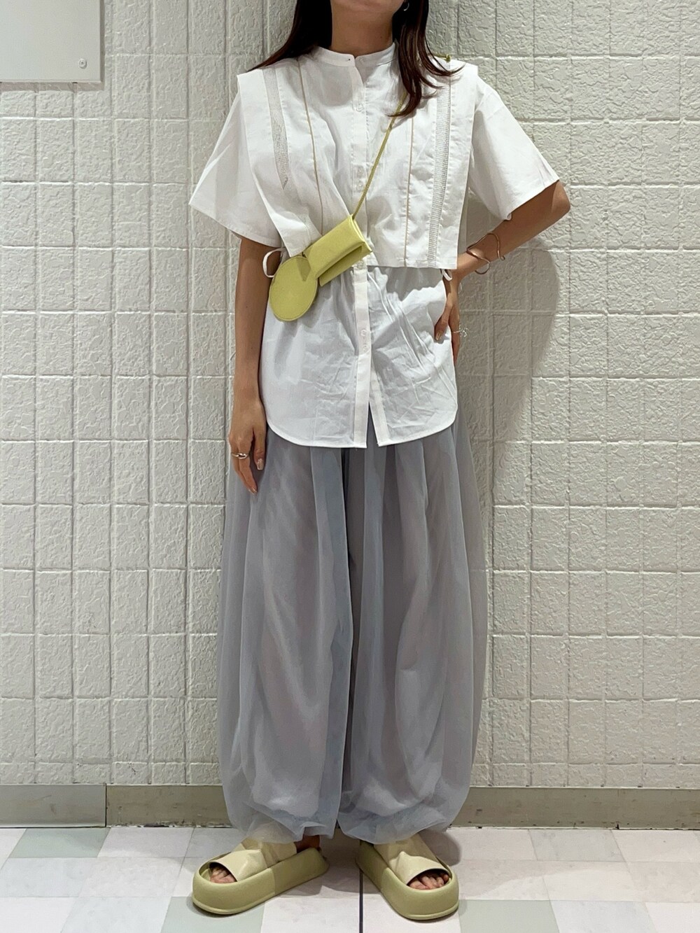 ホワイト系のシャツ/ブラウス、イエロー系のショルダーバッグ、グレー系のその他パンツを着用したレディースの夏コーディネートの2枚目の写真