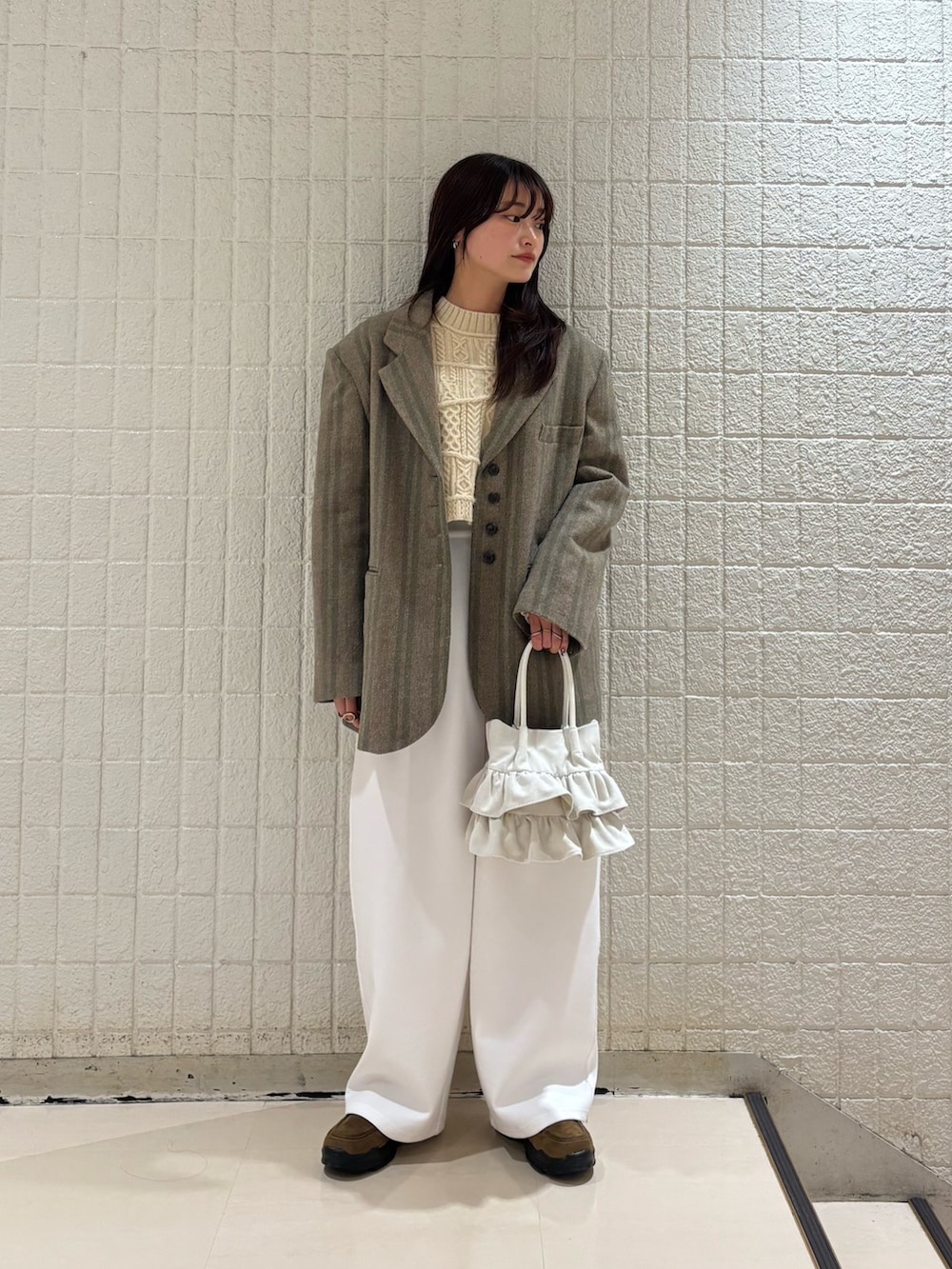 グリーン系のその他アウター、ベージュ系のニット/セーター、ホワイト系のその他パンツを着用したレディースの冬コーディネートの2枚目の写真