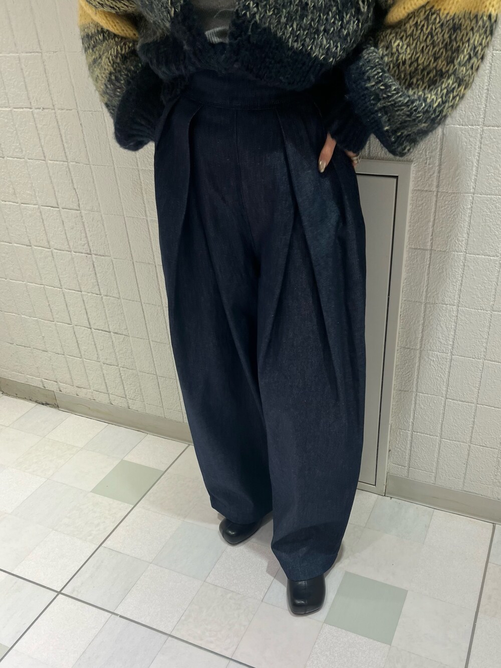 ブルー系のデニムパンツ、ブラック系のブーツ、ブルー系のカーディガン/ボレロを着用したレディースの冬コーディネートの4枚目の写真