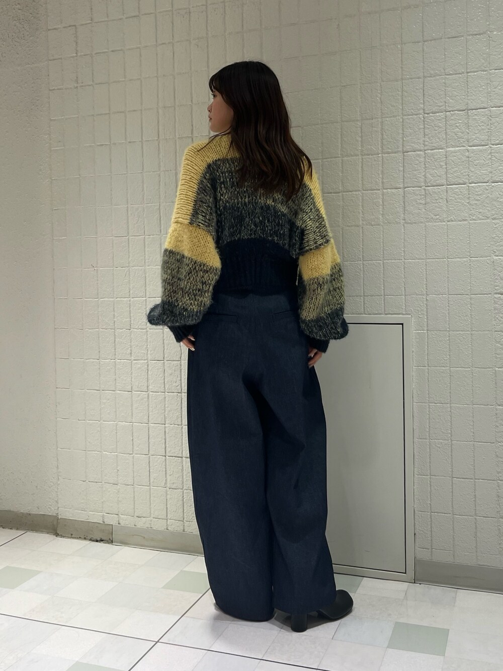 ブルー系のデニムパンツ、ブラック系のブーツ、ブルー系のカーディガン/ボレロを着用したレディースの冬コーディネートの3枚目の写真