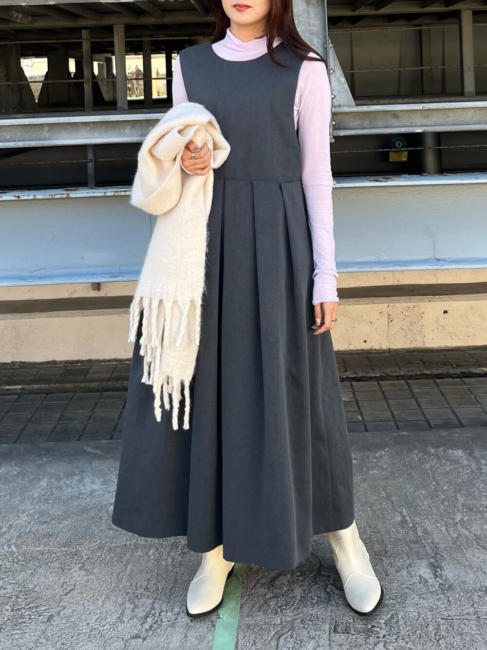 グレー系のステンカラーコート、グレー系のワンピース、ホワイト系のブーツを着用したレディースの春コーディネートの5枚目の写真