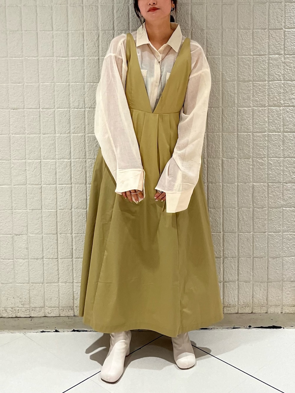 ベージュ系のワンピース、ホワイト系のシャツ/ブラウス、ホワイト系のブーツを着用したレディースの冬コーディネートの2枚目の写真