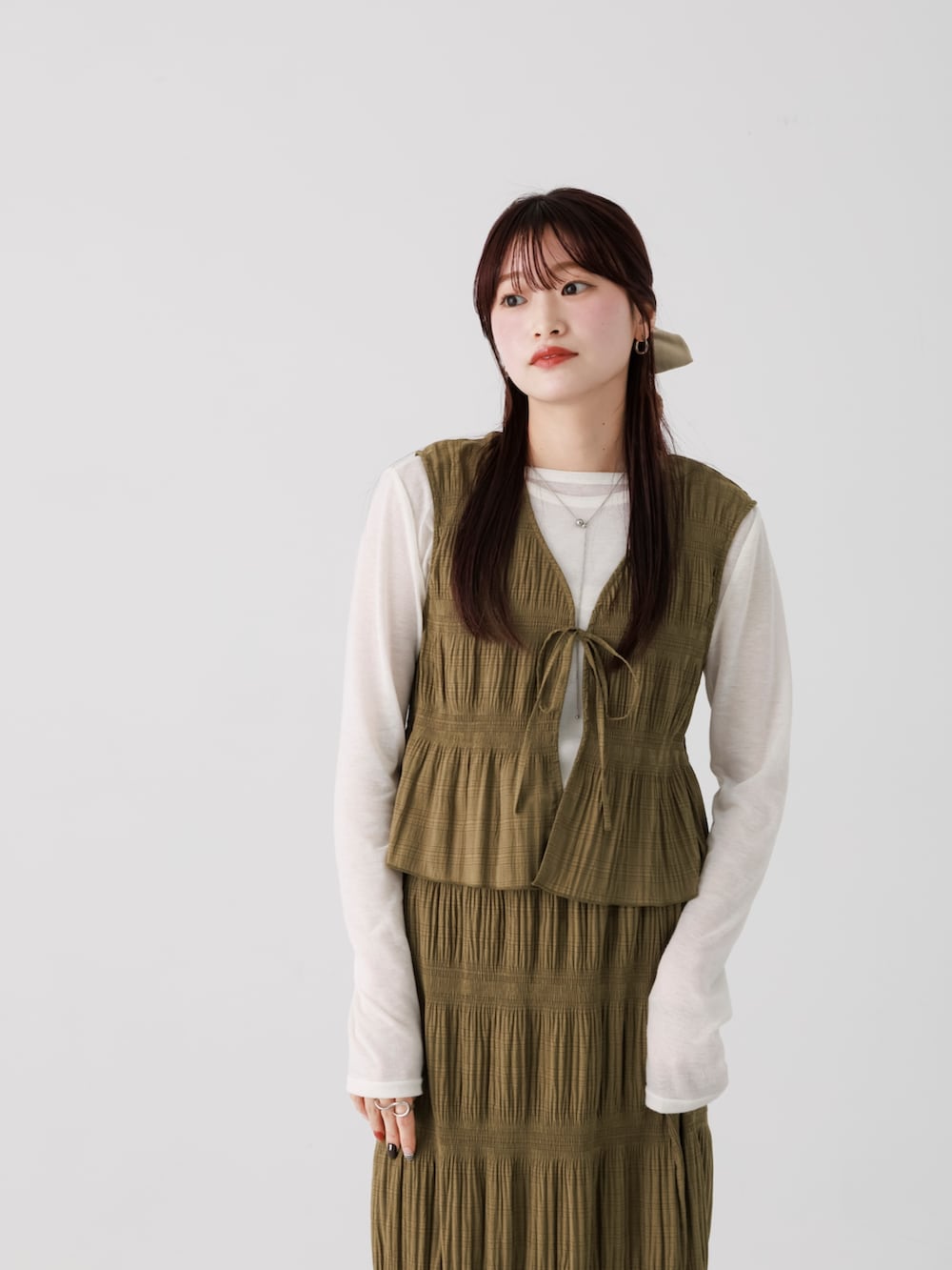 グリーン系のセットアップ、ホワイト系のTシャツ/カットソー、ホワイト系のパンプスを着用したレディースの冬コーディネートの4枚目の写真