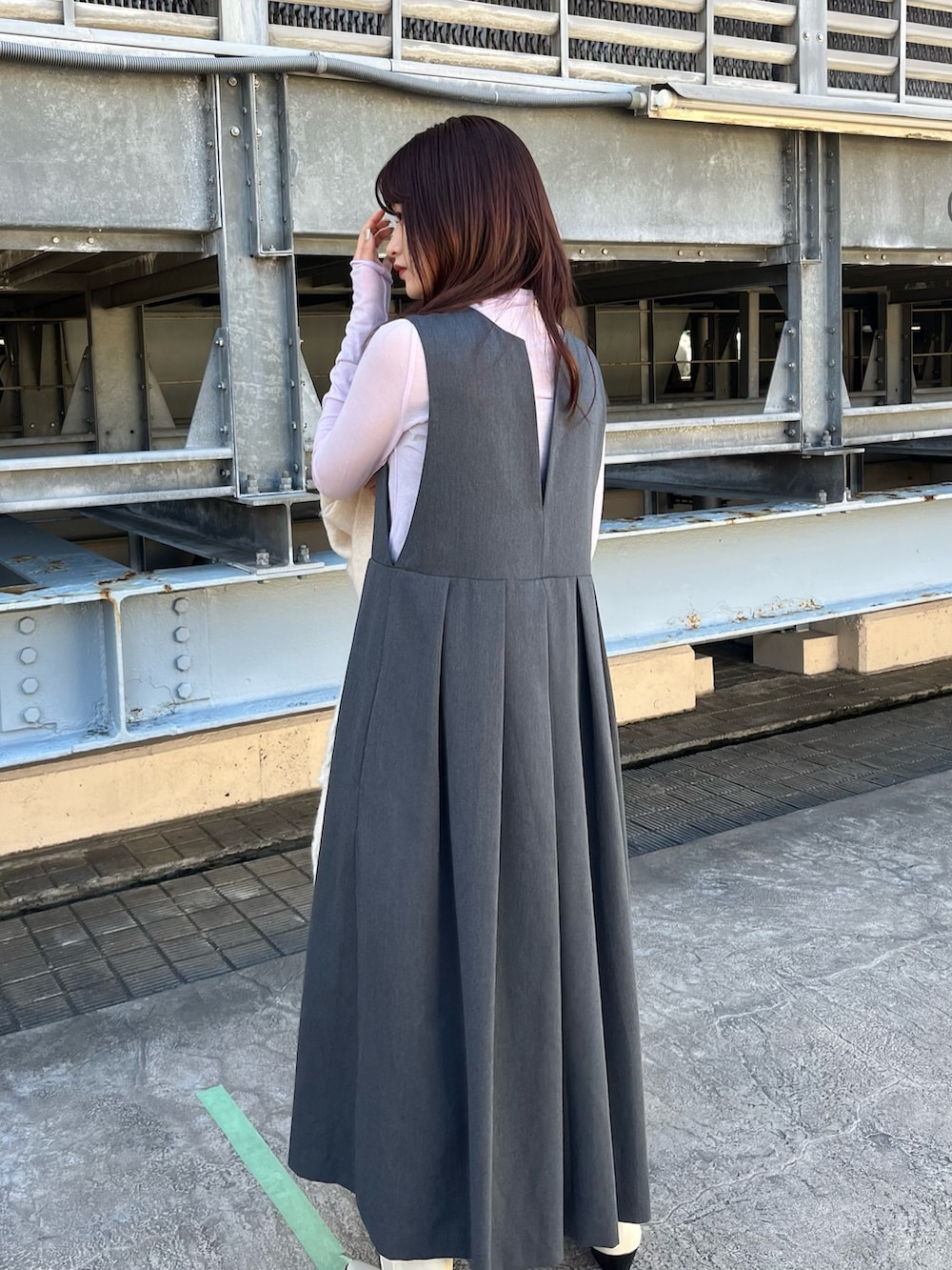 グレー系のステンカラーコート、グレー系のワンピース、ホワイト系のブーツを着用したレディースの春コーディネートの6枚目の写真