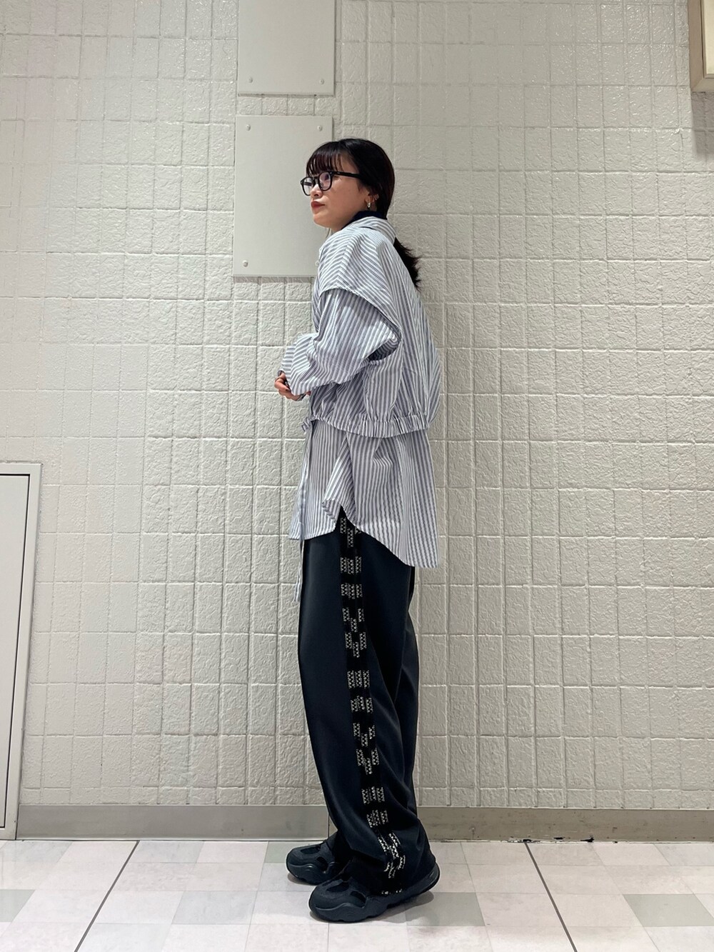 グレー系のステンカラーコート、ホワイト系のシャツ/ブラウス、グレー系のその他パンツを着用したレディースの春コーディネートの5枚目の写真