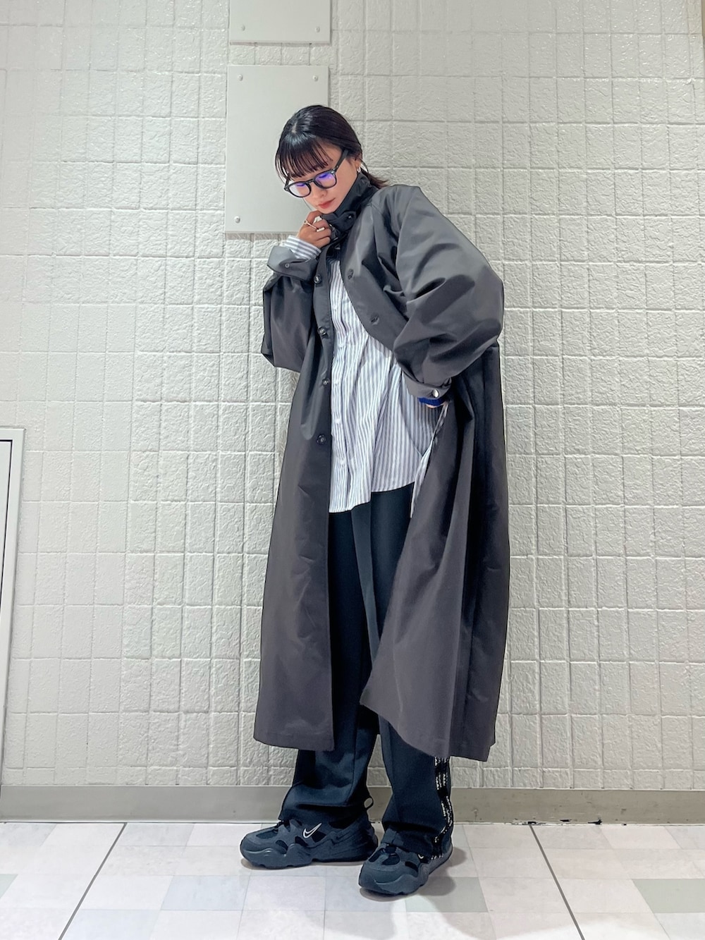 グレー系のステンカラーコート、ホワイト系のシャツ/ブラウス、グレー系のその他パンツを着用したレディースの春コーディネートの3枚目の写真