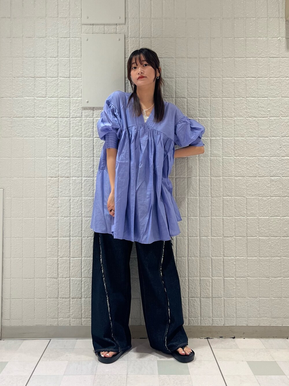 ブルー系のワンピース、ブルー系のデニムパンツ、ブラック系のサンダルを着用したレディースの夏コーディネートの3枚目の写真