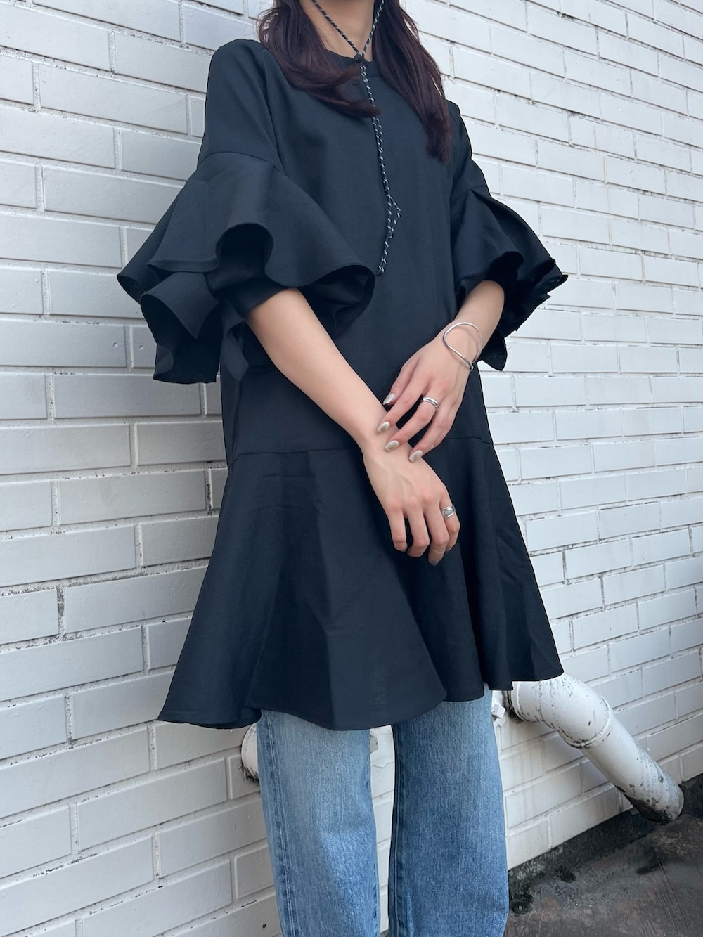 ブラック系のワンピース、ブラック系のブーツ、ブラック系のキャップを着用したレディースの春コーディネートの3枚目の写真