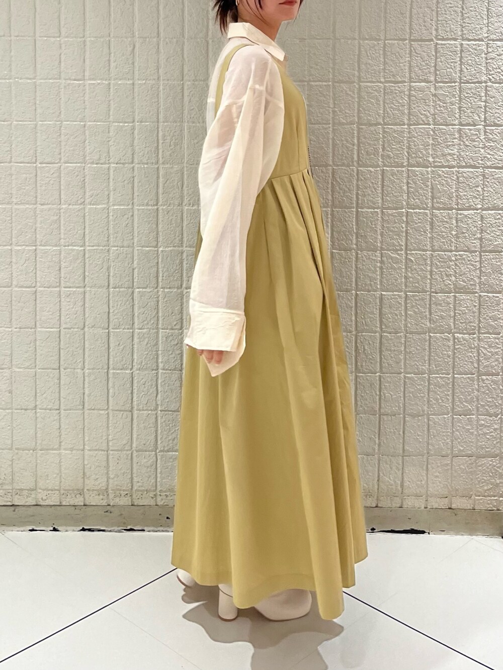 ベージュ系のワンピース、ホワイト系のシャツ/ブラウス、ホワイト系のブーツを着用したレディースの冬コーディネートの4枚目の写真