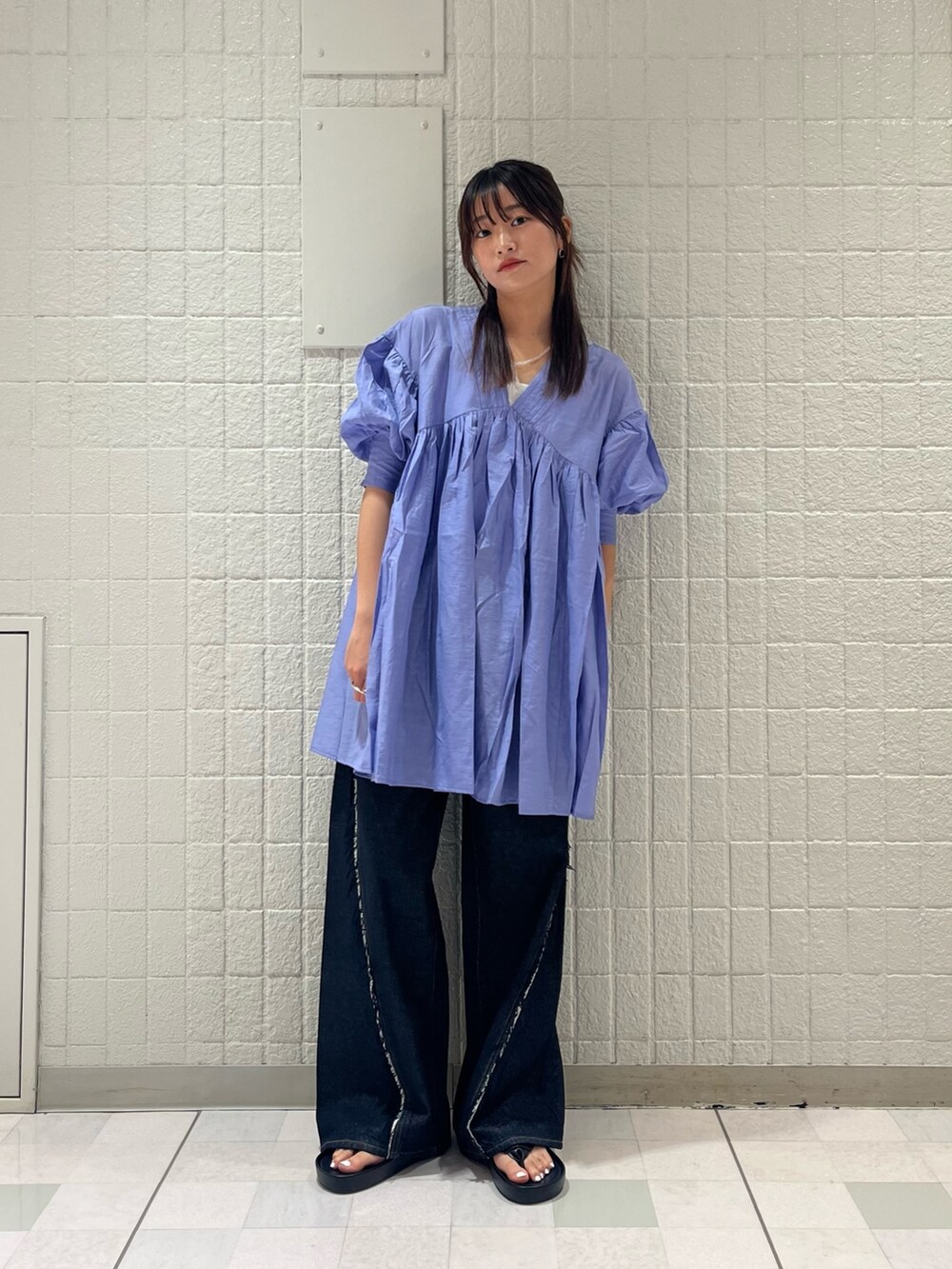 ブルー系のワンピース、ブルー系のデニムパンツ、ブラック系のサンダルを着用したレディースの夏コーディネートの2枚目の写真