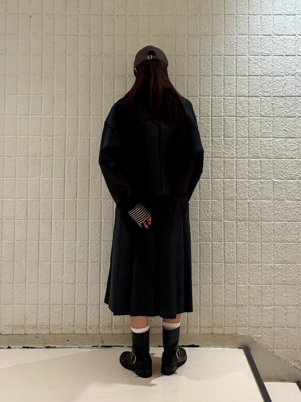 グレー系のTシャツ/カットソー、ブラック系のその他アウター、グレー系のスカートを着用したレディースの冬コーディネートの3枚目の写真