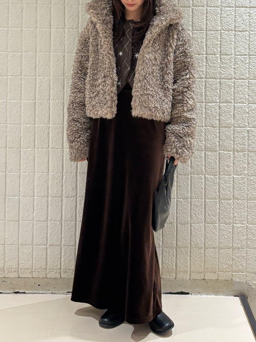 ベージュ系のその他アウター、ブラウン系のニット/セーター、ブラウン系のスカートを着用したレディースの秋コーディネートの3枚目の写真