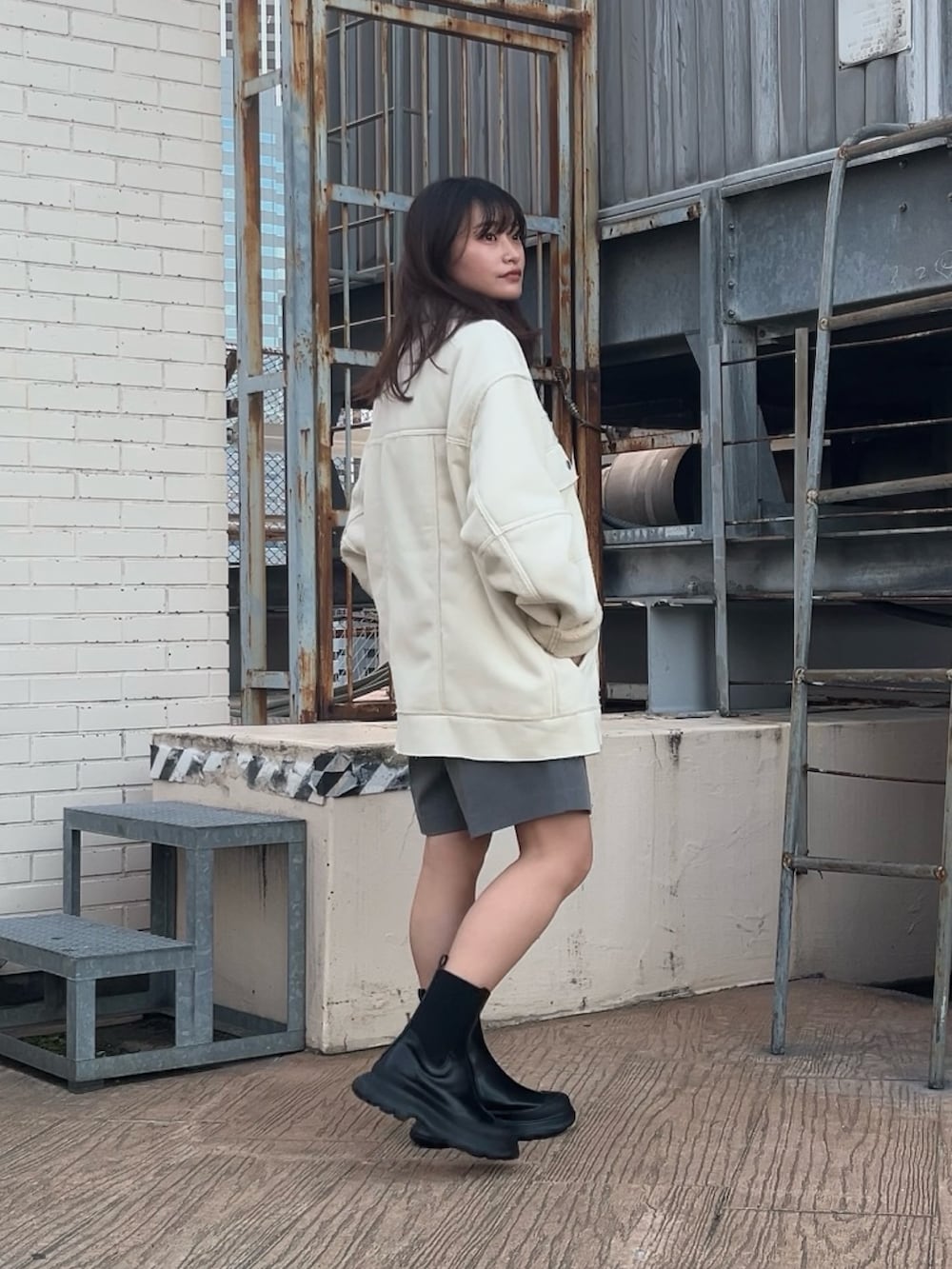 ホワイト系のその他アウター、グレー系のその他パンツ、ブラック系のブーツを着用したレディースの冬コーディネートの3枚目の写真
