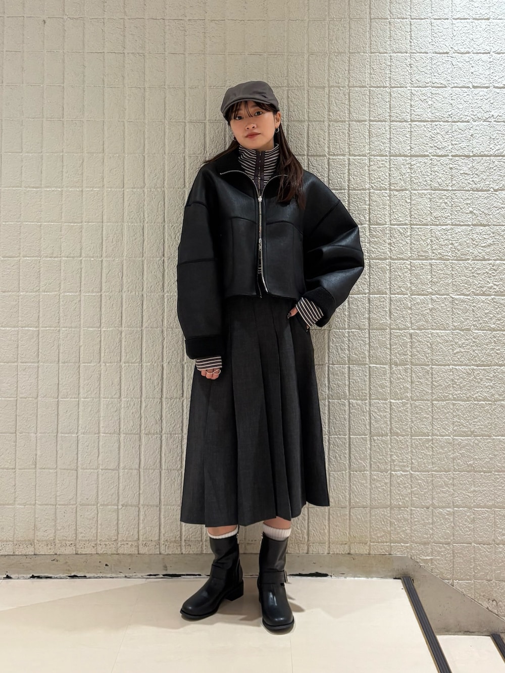 グレー系のTシャツ/カットソー、ブラック系のその他アウター、グレー系のスカートを着用したレディースの冬コーディネートの2枚目の写真