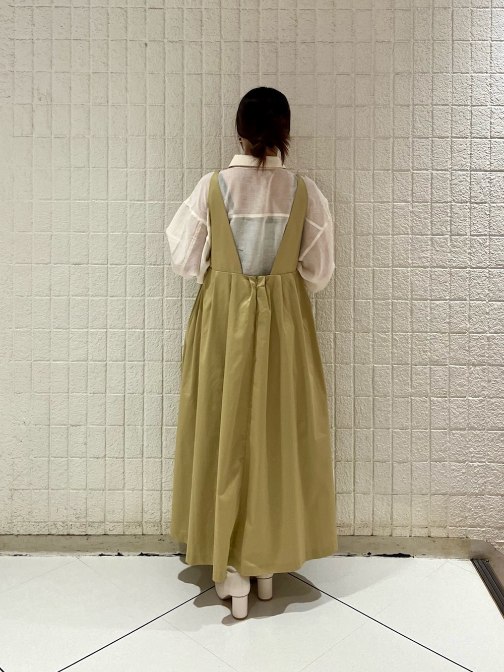 ベージュ系のワンピース、ホワイト系のシャツ/ブラウス、ホワイト系のブーツを着用したレディースの冬コーディネートの3枚目の写真