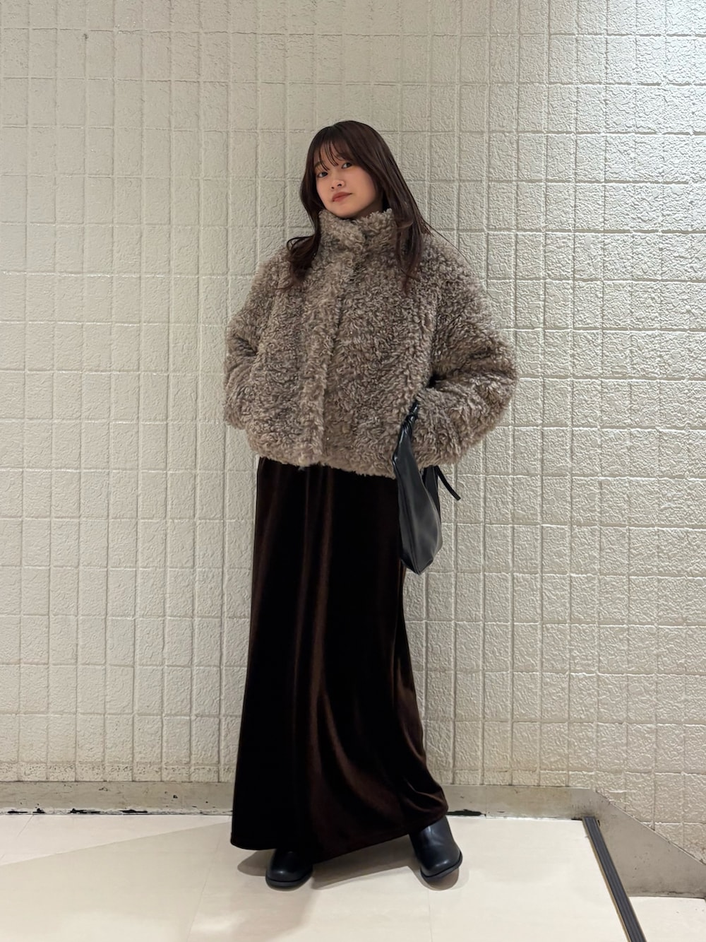 ベージュ系のその他アウター、ブラウン系のニット/セーター、ブラウン系のスカートを着用したレディースの秋コーディネートの2枚目の写真