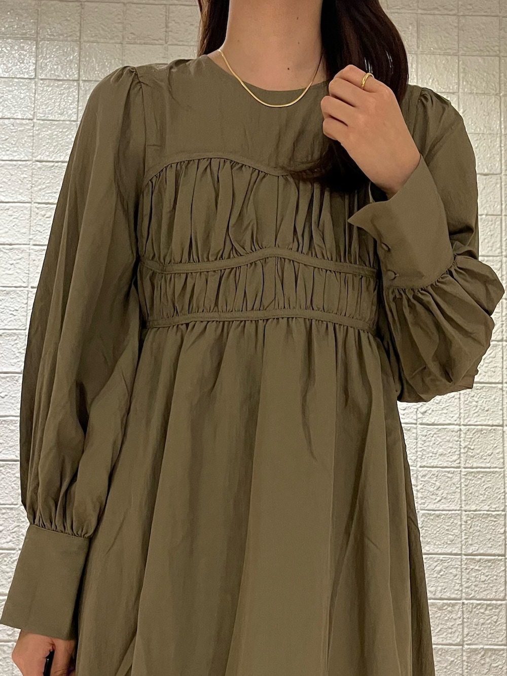 ブラウン系のワンピース、ホワイト系のベスト、ホワイト系のブーツを着用したレディースの春コーディネートの4枚目の写真