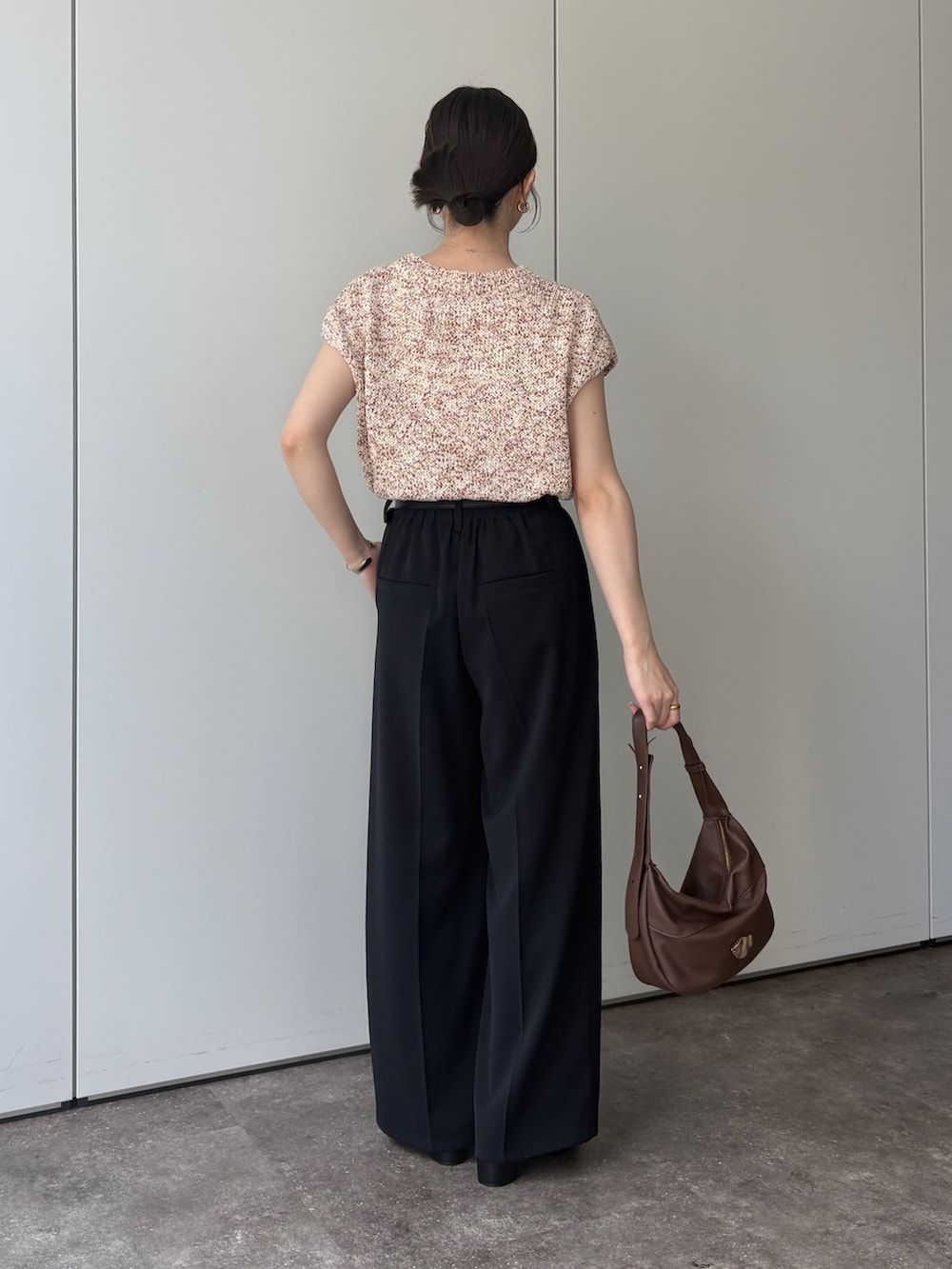 ピンク系のニット/セーター、ブラック系のスラックス、ブラック系のパンプスを着用したレディースの春コーディネートの3枚目の写真