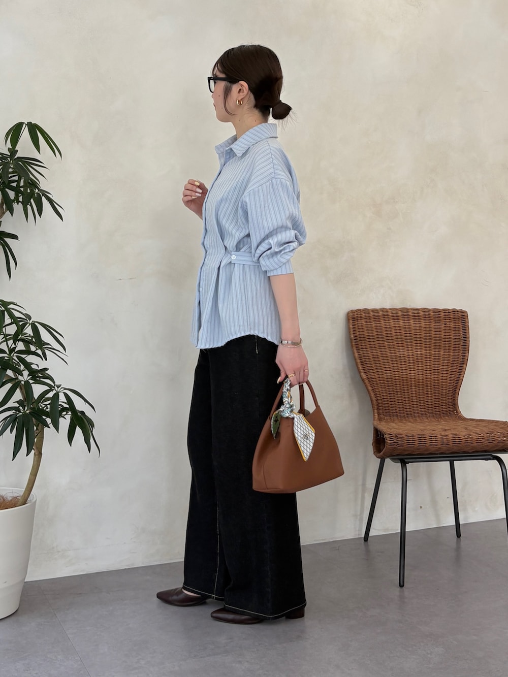 ブルー系のシャツ/ブラウス、ブラック系のその他パンツ、ブラウン系のトートバッグを着用したレディースの春コーディネートの2枚目の写真