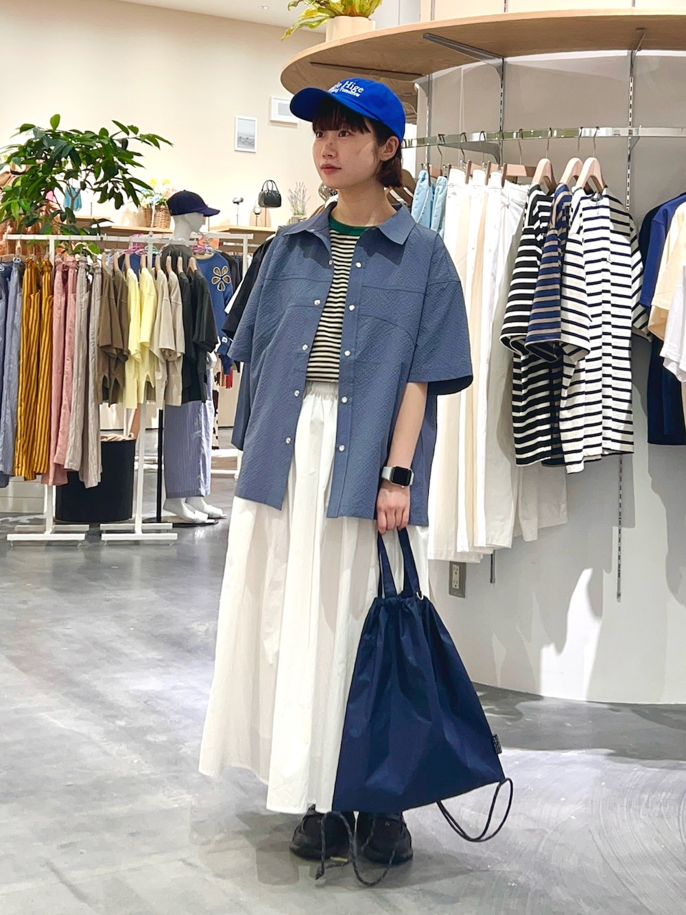 ブルー系のシャツ/ブラウス、グリーン系のTシャツ/カットソー、ホワイト系のスカートを着用したレディースの夏コーディネートの2枚目の写真