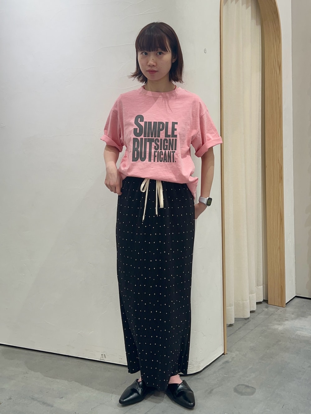 ピンク系のTシャツ/カットソー、ホワイト系のトートバッグ、ブラック系のスカートを着用したレディースの春コーディネートの2枚目の写真
