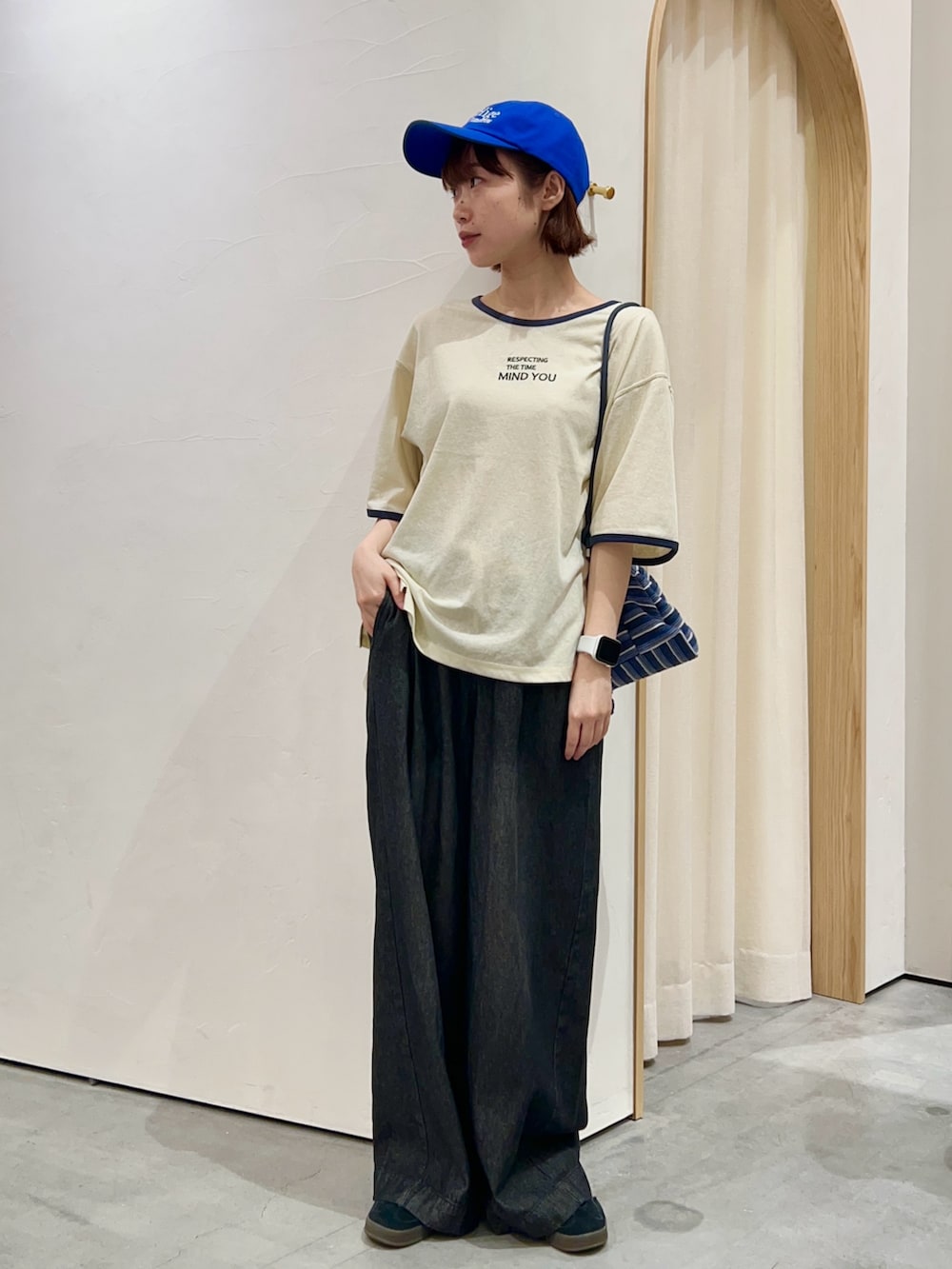 ホワイト系のTシャツ/カットソー、ブルー系のショルダーバッグ、ブラック系のデニムパンツを着用したレディースの夏コーディネートの2枚目の写真