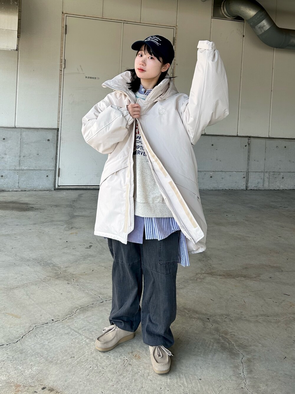 ホワイト系のジャケット/アウター、ブラック系のデニムパンツ、ブルー系のキャップを着用したレディースの秋コーディネートの2枚目の写真
