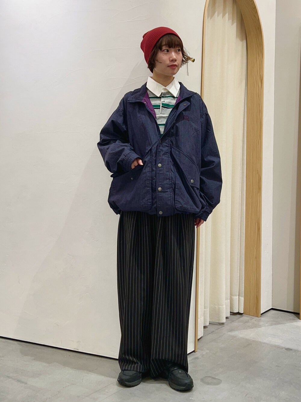 グレー系のTシャツ/カットソー、ブルー系のナイロンジャケット、ブラック系のスラックスを着用したレディースの秋コーディネートの2枚目の写真