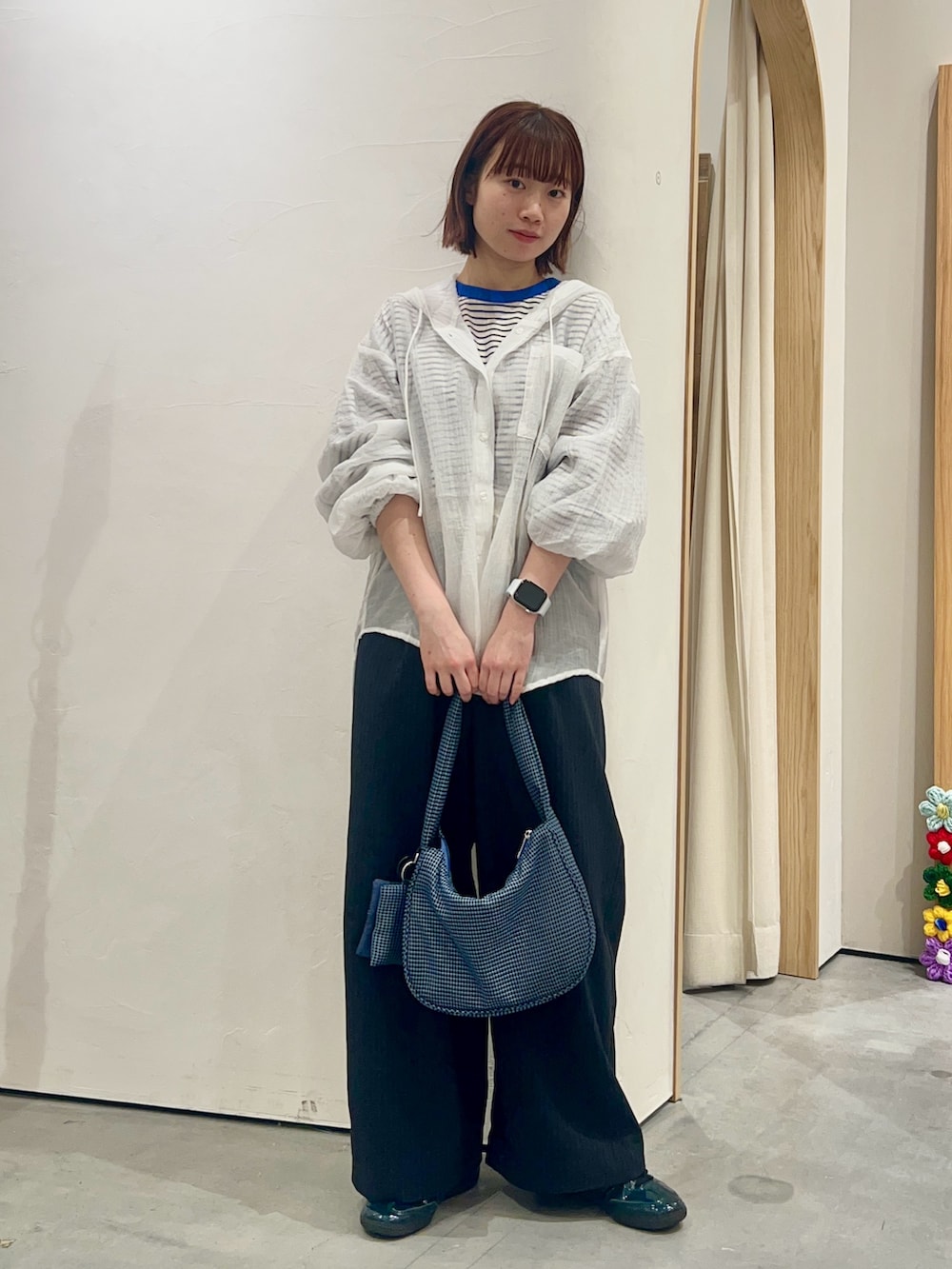 ホワイト系のシャツ/ブラウス、ブルー系のショルダーバッグ、ブラック系のスラックスを着用したレディースの春コーディネートの2枚目の写真