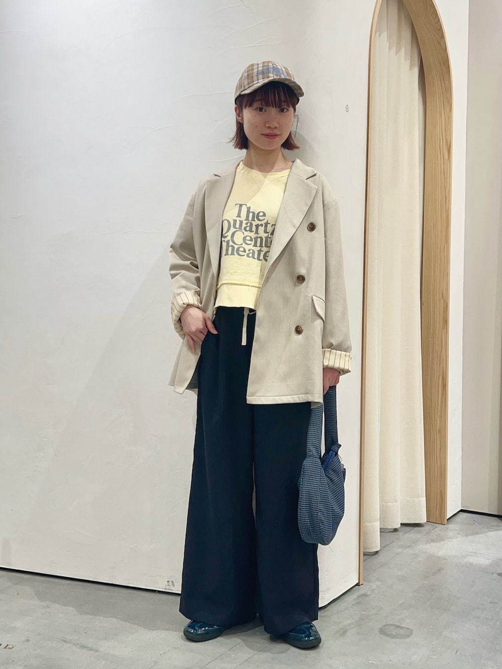 イエロー系のスウェット、ホワイト系のテーラードジャケット、ブルー系のショルダーバッグを着用したレディースの春コーディネートの2枚目の写真